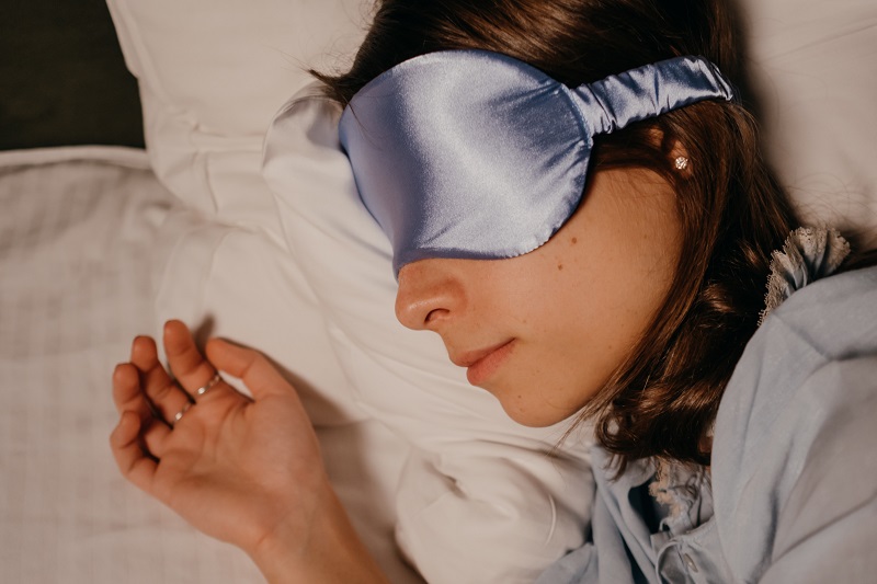 CBD Melatonin Gummies Close Up of a Person Sleeping with a Blindfold On