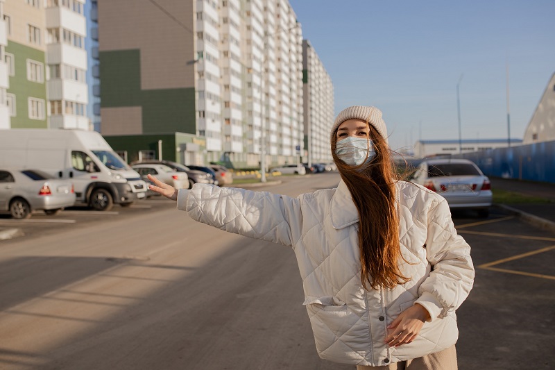 CBD has Potential to Help Prevent COVID-19 Infection Woman Hailing a Cab While Wearing a Face Mask