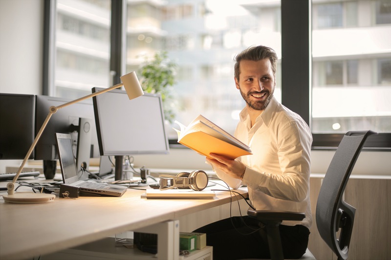 CBD Dosage Man Smiling Working at a Desk in an Office