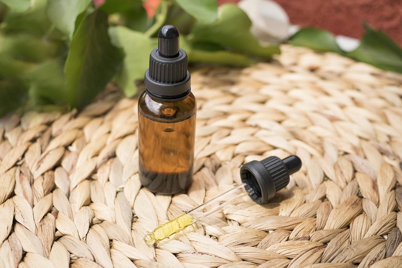 Good Manufacturing Practices for CBD Close Up of a Dropper Bottle of CBD Oil Sitting on a Woven Surface