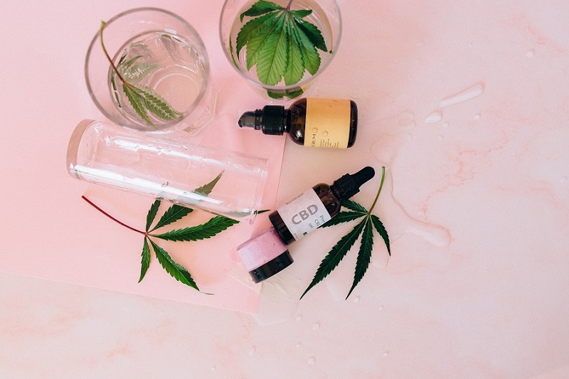 How Long will CBD Tinctures Last in the Bottle Overhead View of CBD Oil Bottles with hemp Leaves Scattered Around