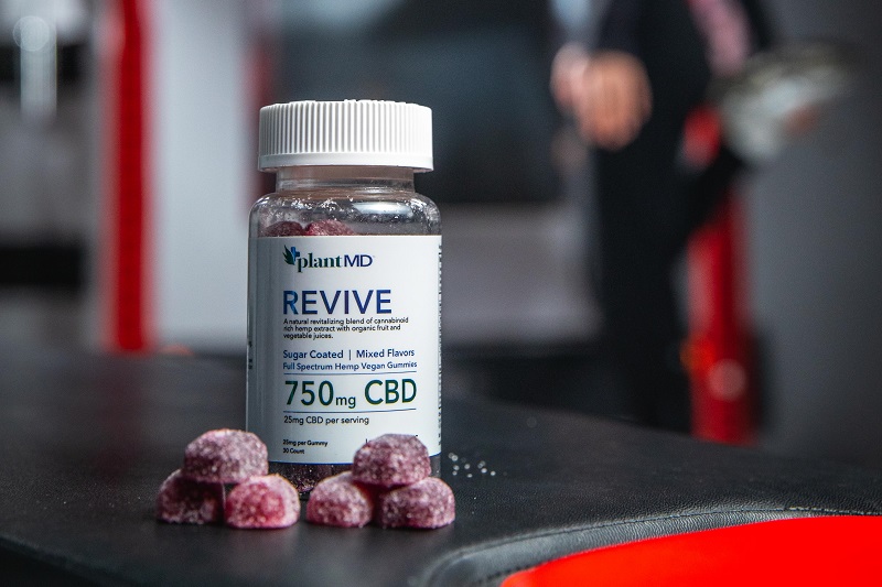 Where to Buy Revive CBD Gummies Close Up of a Bottle of Revive Gummies with a Few Scattered in Front of the Bottle