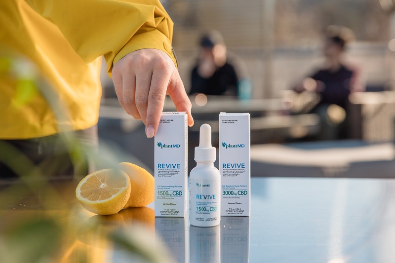 PlantMDs Unique Beta-CP Complex Benefits Person Reaching for PlantMD Products on a Table with a Half a Lemon Sitting Next to the Products