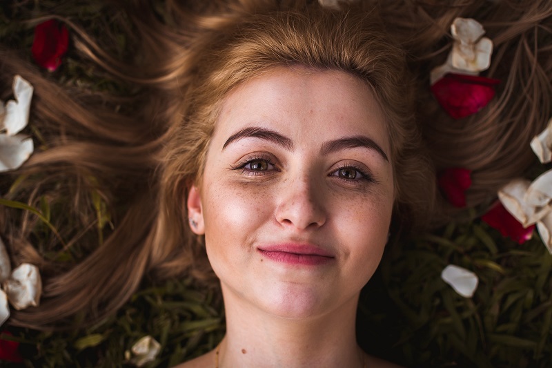 CBD Oil Benefits for the Skin Woman Laying Down with Flowers in Her Hair