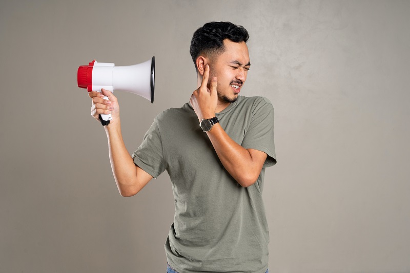 Can CBD Help Tinnitus Man Holding a a Megaphone Towards His Ear While Using His Other Hand to Cover His Ear