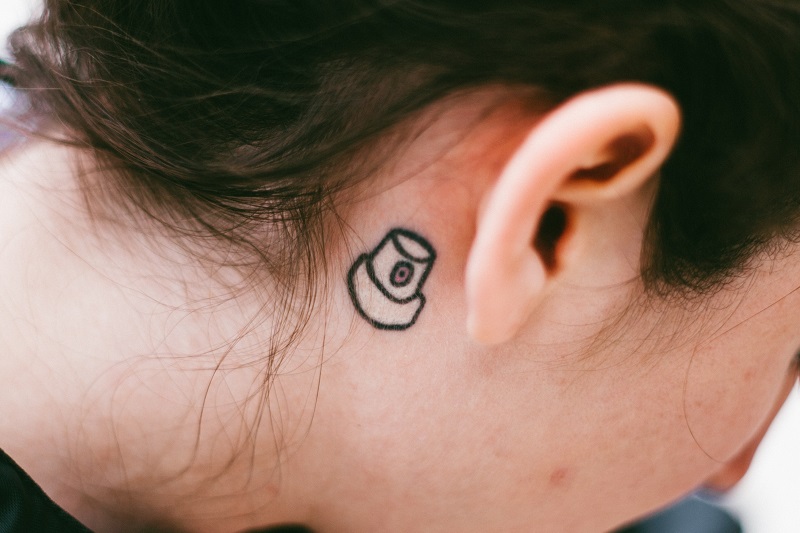 Can CBD Help Tinnitus Close Up of a Woman's Ear with a Small Tattoo Behind it
