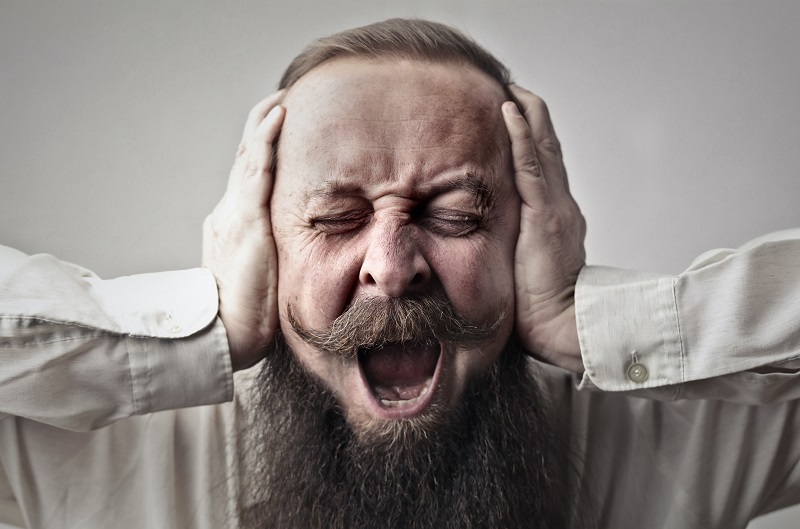 Can CBD Help Tinnitus Man Covering His Ears with an Angry Look on His Face