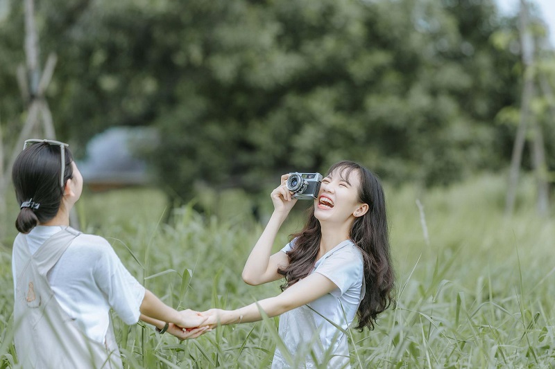 How CBD Helps with Periods Two Women Taking Pictures of Each Other Outside in a Field