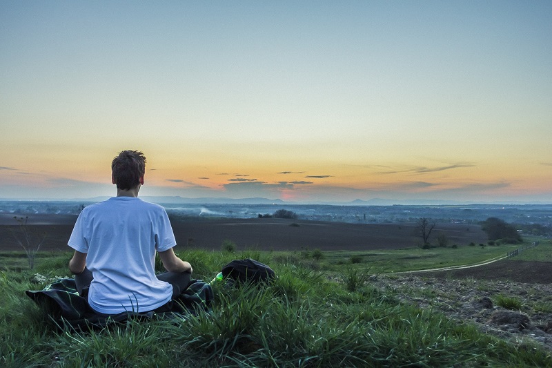 How to Use CBD for Meditation Man Meditating in a Field