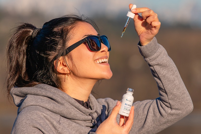 Best Time of Day to Take CBD Woman Taking PlantMD Revive Tincture