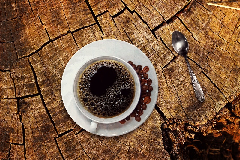CBD Coffee Recipes Overhead View of a Cup of Coffee Sitting on a Tree Stump